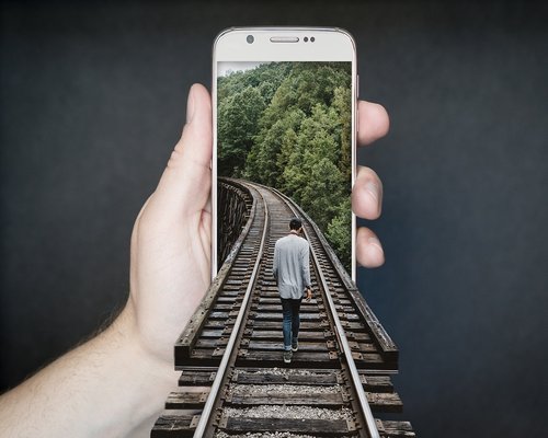 Close up of hands holding a smartphone with adjusted low brightness in an office setting